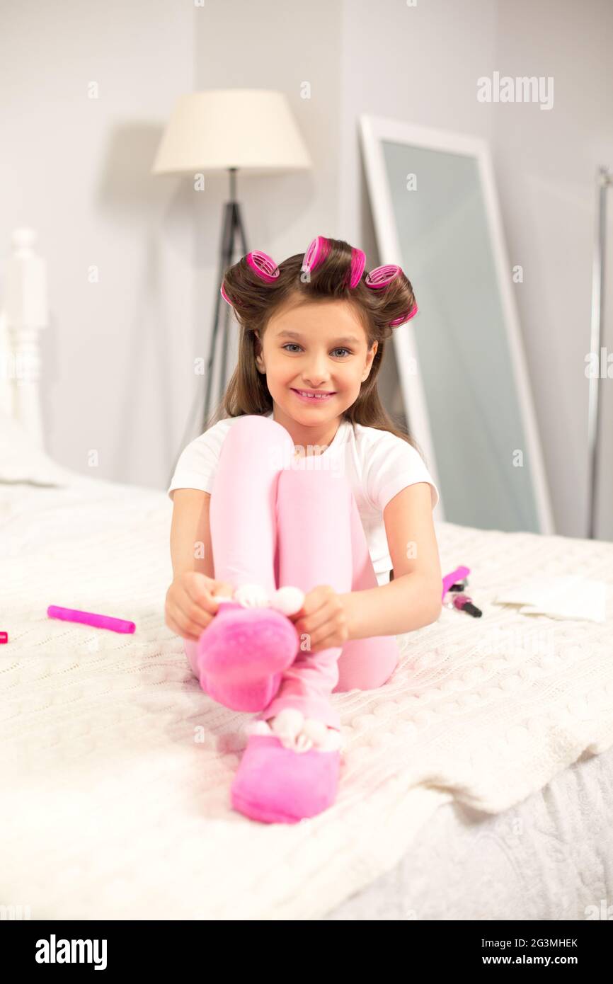 Cute girl putting chaussons sur. Banque D'Images