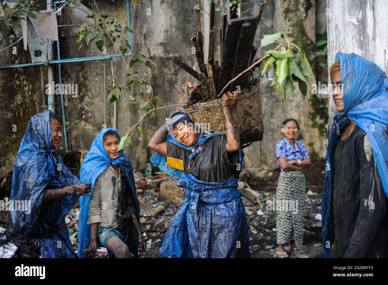 '19.02.2014, Yangon, , Myanmar - UN groupe de nettoyeurs d'égout dans des vêtements de protection simples faits de sacs en plastique déchirés de nettoyage de la ville bouchées le coulis ouvert Banque D'Images