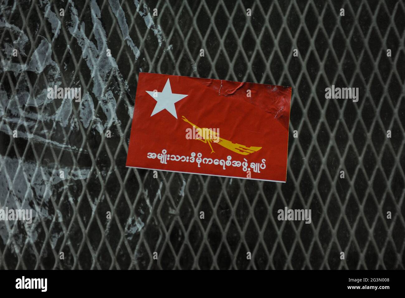 '29.10.2015, Yangon, , Myanmar - UN autocollant rouge avec le logo et le libellé du parti NLD (National League for Democracy) est coincé sur une clôture dans le f Banque D'Images