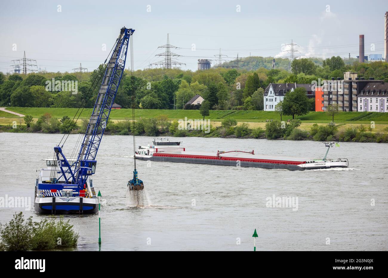 '19.05.2021, Duisburg, Rhénanie-du-Nord-Westphalie, Allemagne - Paysage urbain dans la région de la Ruhr avec des navires de cargaison sur le Rhin devant des maisons résidentielles dans le TH Banque D'Images