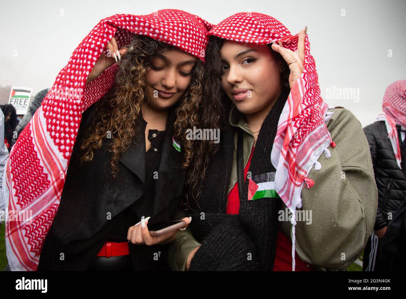 Deux jeunes femmes se protégeant de la pluie avec un keffiyeh à la manifestation Free Palestine, Londres, 22.5.2021 Banque D'Images
