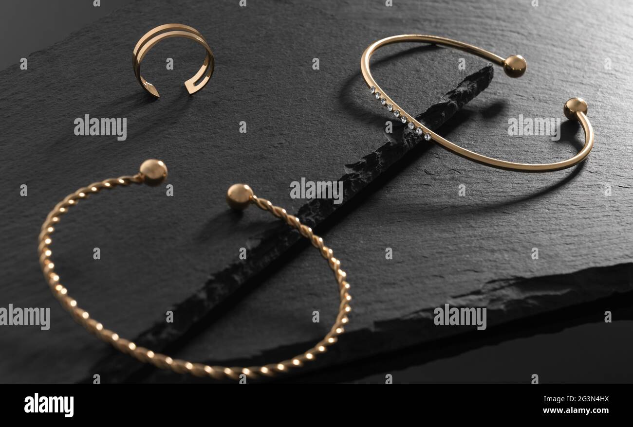 Bracelet moderne avec diamants et anneau moderne sur plaques de pierre noires Banque D'Images
