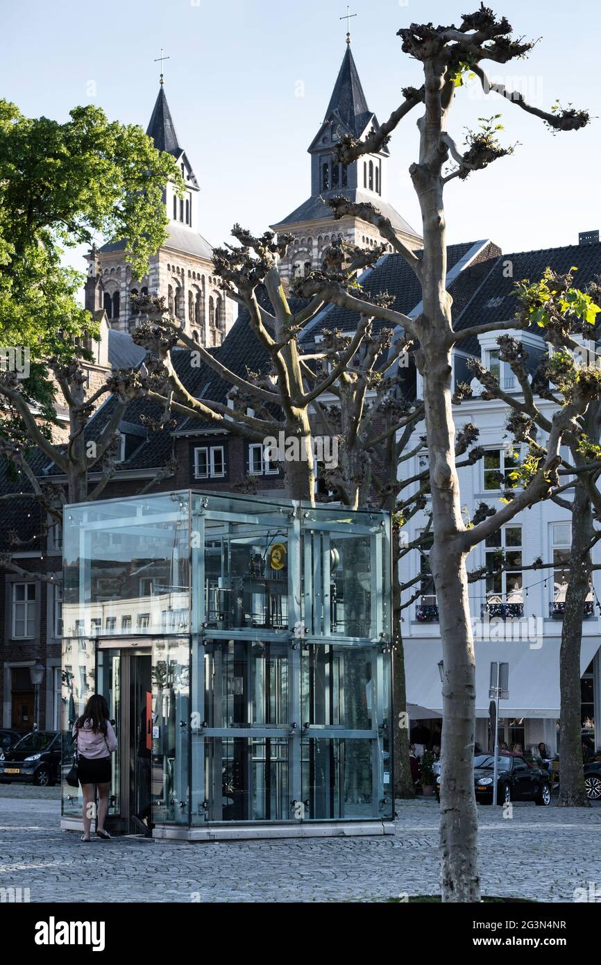 Les gens entrent dans un ascenseur en verre au-dessus du sol qui mène à un garage sur la place Vrijthof à Maastricht Banque D'Images