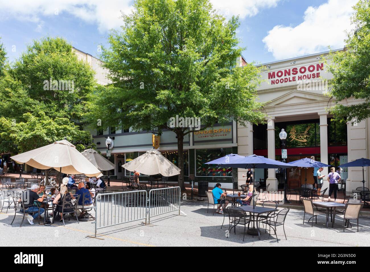 SPARTANBURG, SC, USA-13 JUIN 2021: Les gens aux tables de trottoir devant la Maison Monsoon Noodle sur la rue principale. Image horizontale. Banque D'Images