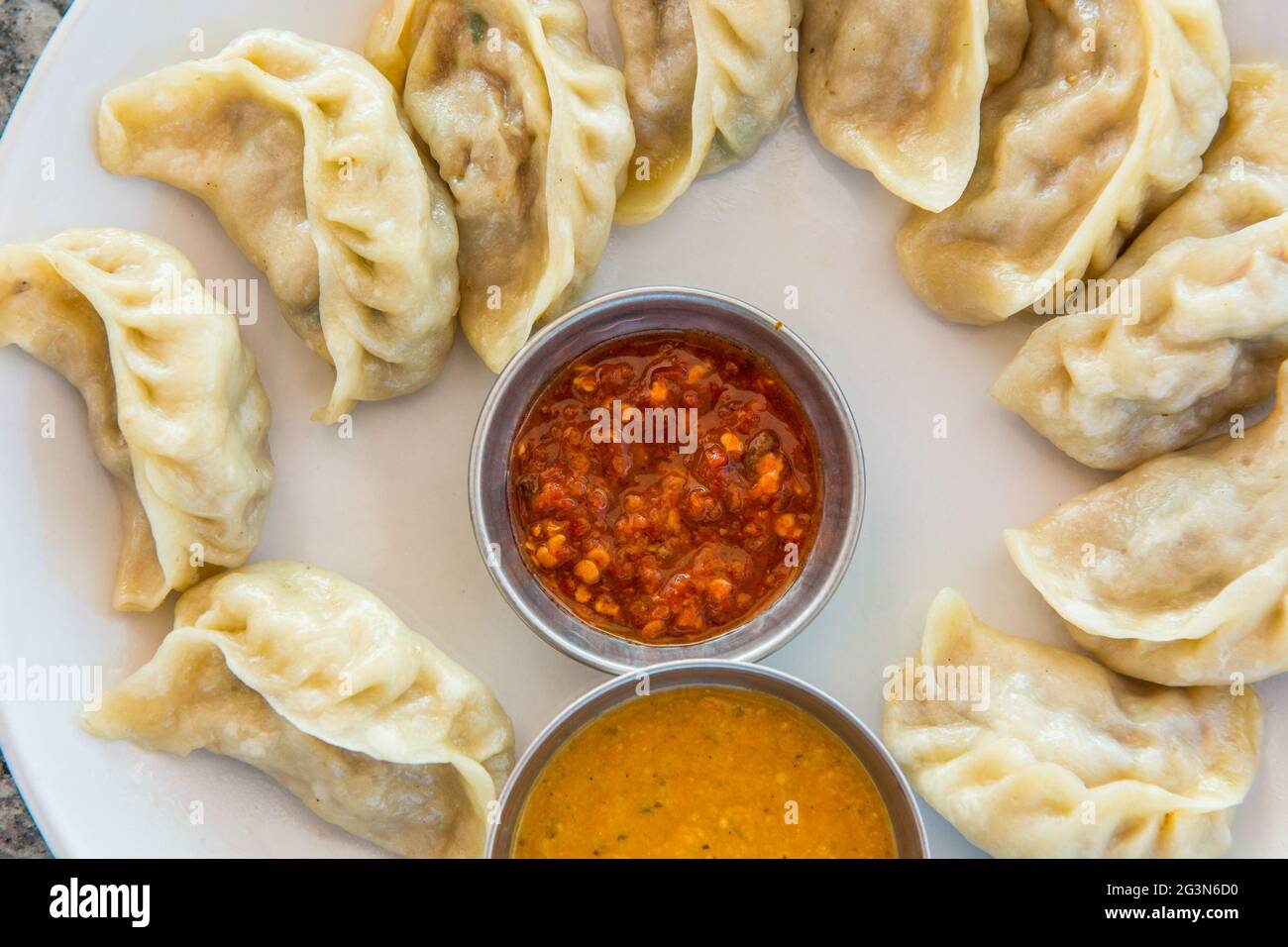 Assiette de momos traditionnels servie avec une délicieuse trempette. Banque D'Images