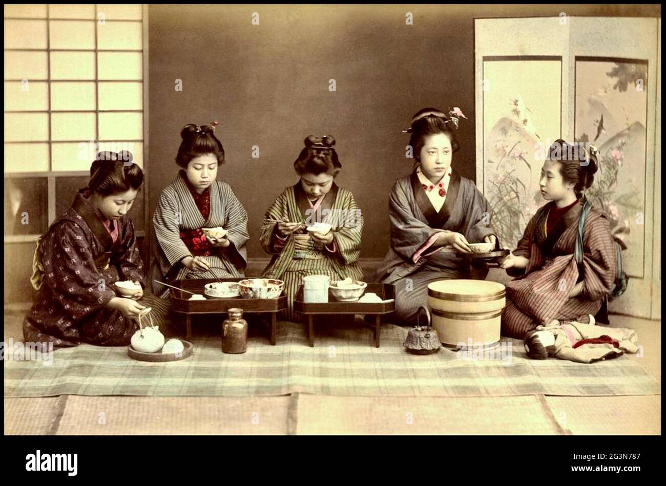 Photo Kusakabe Kimbei d'époque du Vieux Japon - UN groupe de femmes japonaises mangent leur dîner - dîner manger. Banque D'Images