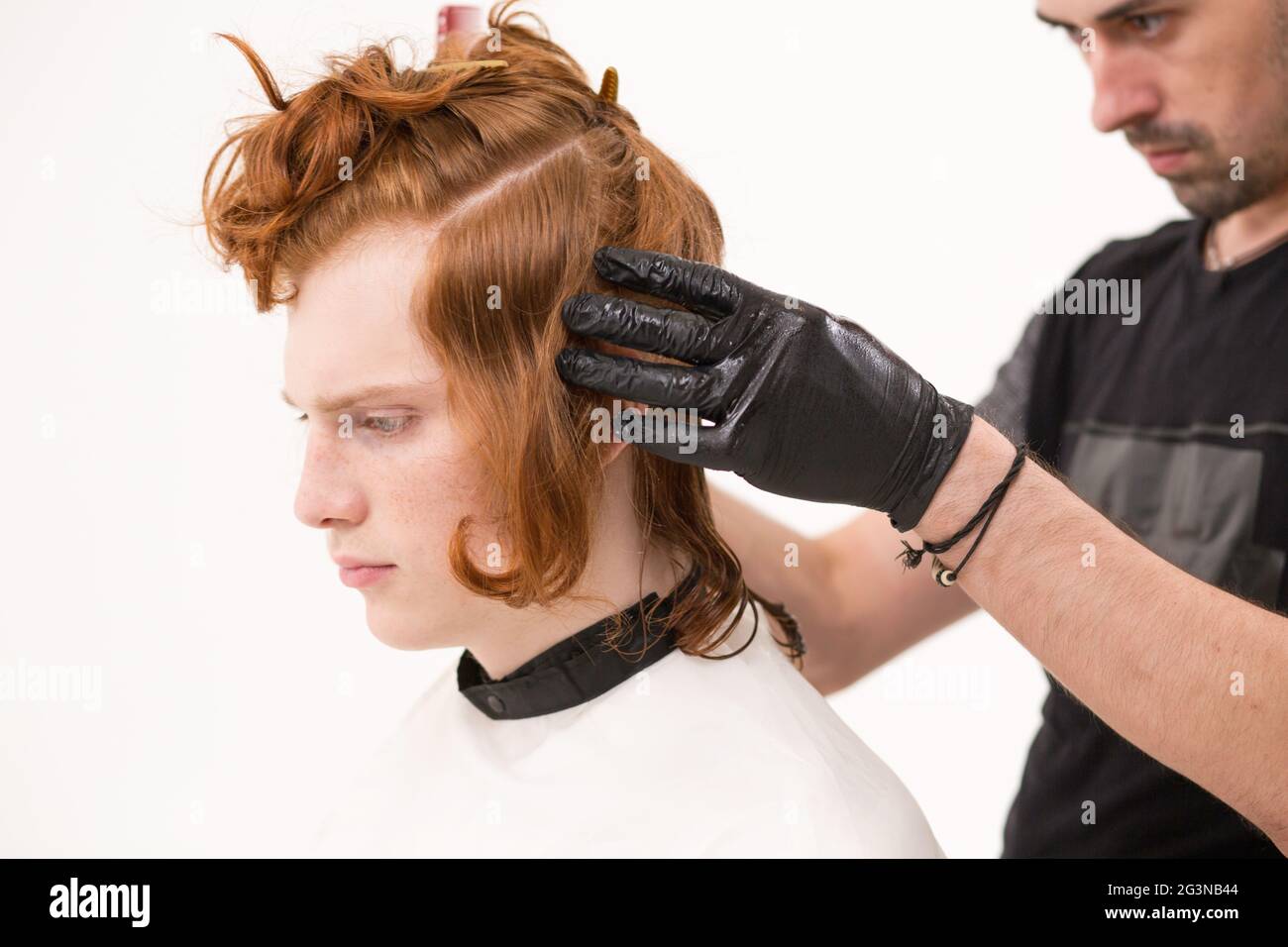 Coiffure L'épinglage un cheveux de son client avec une épingle Banque D'Images