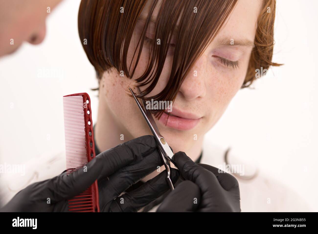 Gros plan du visage de l'homme lorsque ses cheveux roux est coupé Banque D'Images