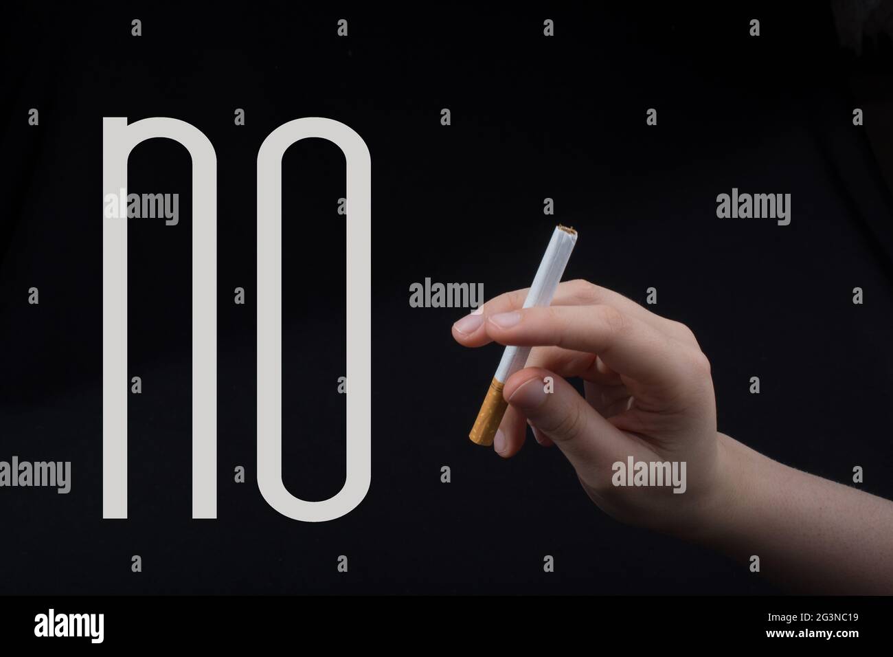 C'est main tenant une cigarette sur fond noir Banque D'Images