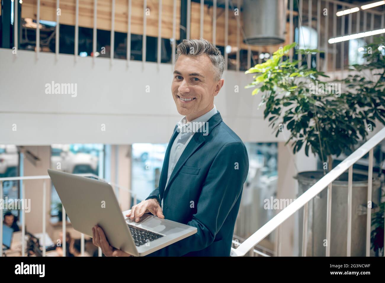 Homme travaillant avec un ordinateur portable dans les escaliers de l'espace de bureau Banque D'Images