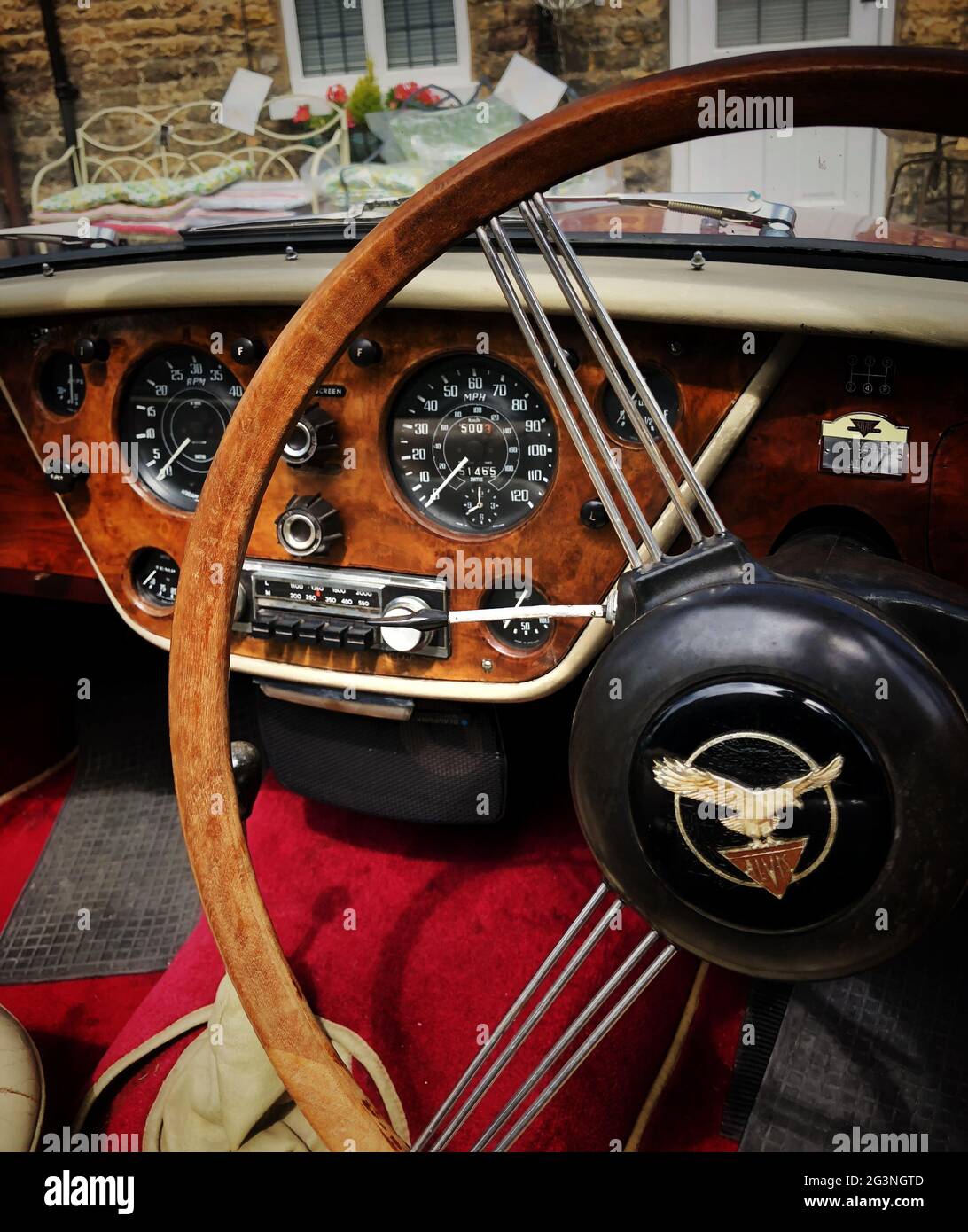 L'intérieur d'une voiture classique avec tableau de bord en bois et volant Banque D'Images