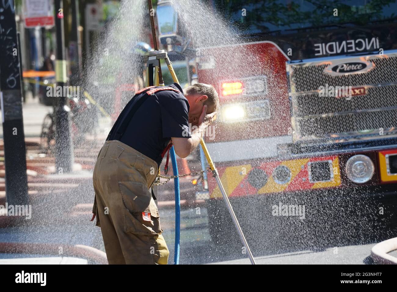 Montréal,Québec,Canada,le 9 juin 2021.un pompier se rafraîchi après avoir lutté contre un incendie par temps chaud.Credit:Mario Beauregard/Alamy News Banque D'Images