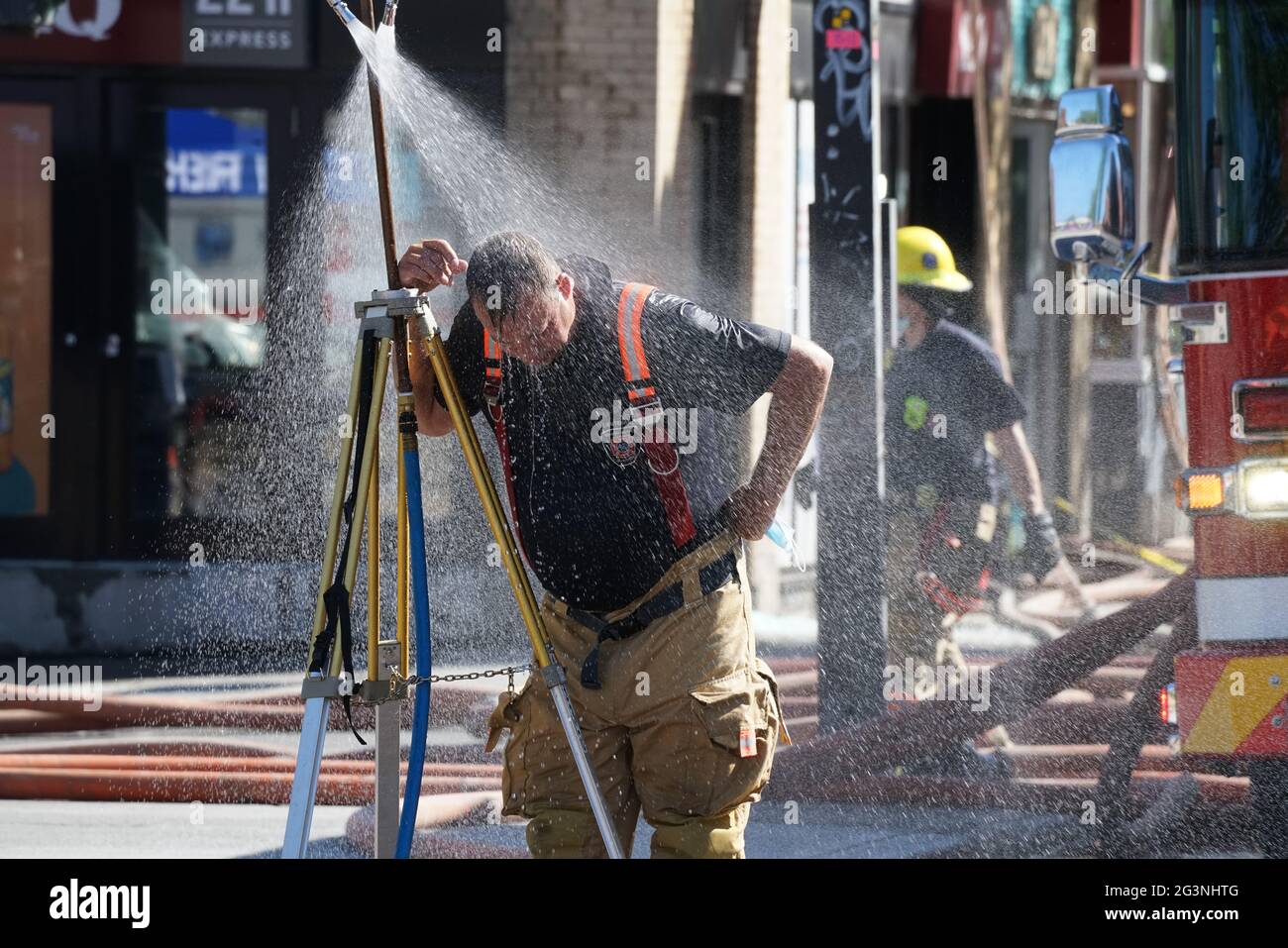 Montréal,Québec,Canada,le 9 juin 2021.un pompier se rafraîchi après avoir lutté contre un incendie par temps chaud.Credit:Mario Beauregard/Alamy News Banque D'Images