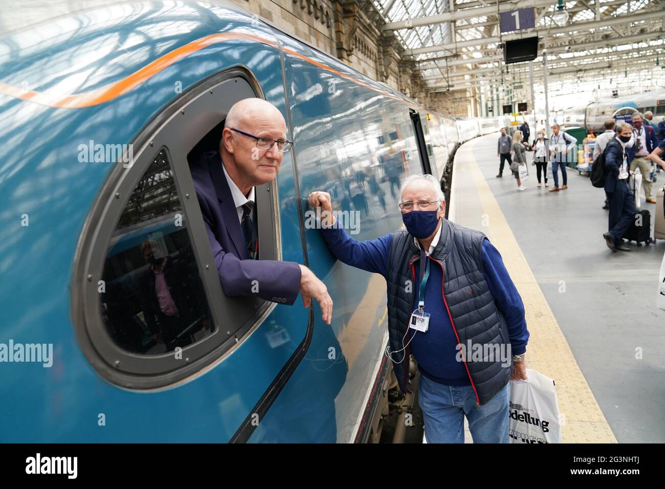 Pete Waterman, fan de train, parle avec le chauffeur de train Neil Barker à bord du train Avanti West Coast Class 390 EMU qui est arrivé à la gare centrale de Glasgow depuis Londres Euston après avoir échoué à battre le record de 36 ans pour le trajet en train le plus rapide entre Londres et Glasgow. Le train Royal Scot est arrivé à Glasgow Central 21 secondes après le record de trois heures, 52 minutes et 40 secondes établi par British Rail en décembre 1984 Date de la photo : jeudi 17 juin 2021. Banque D'Images