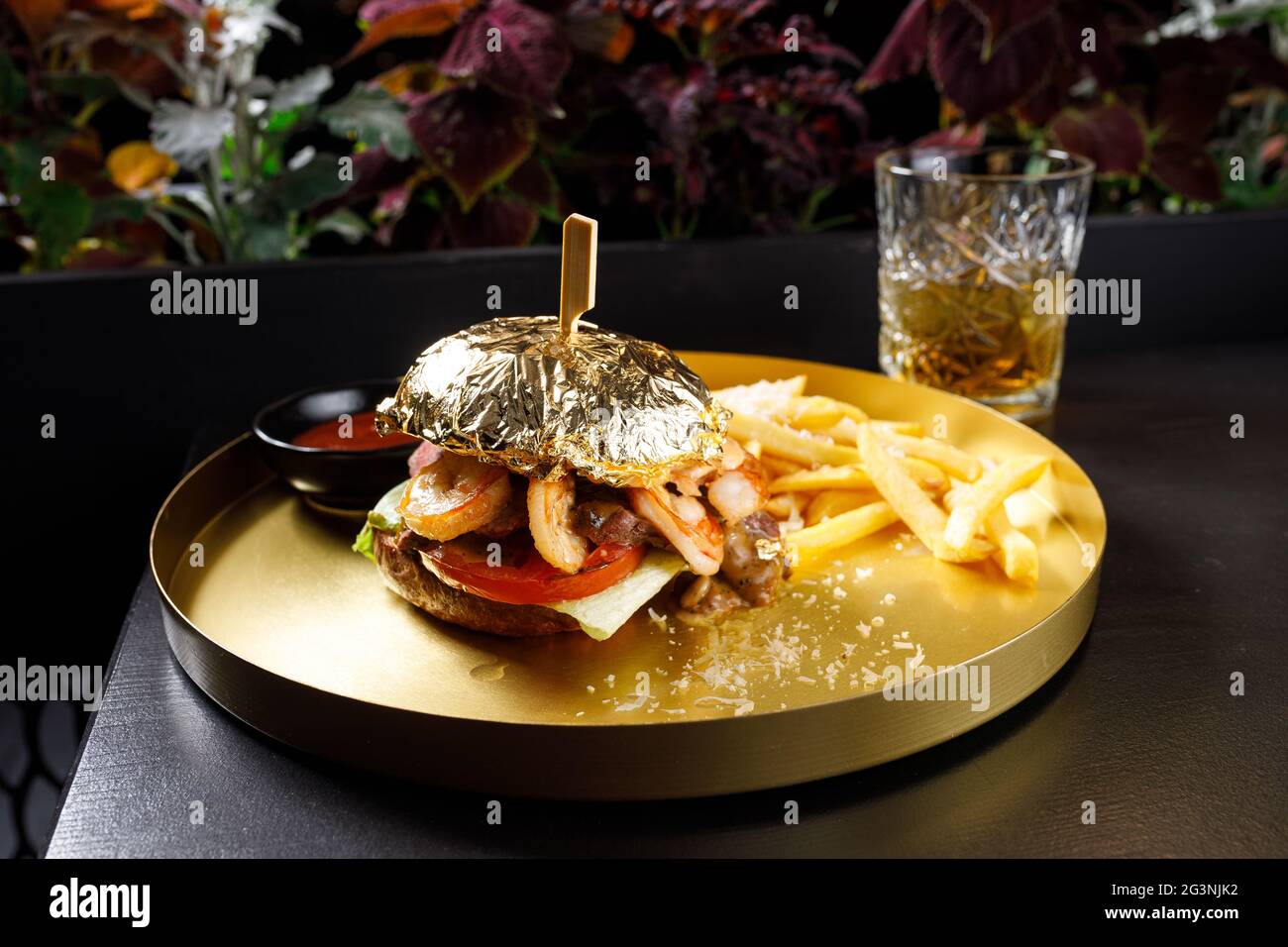 Hamburger au saumon et aux crevettes, mayonnaise sur le petit pain, patty de saumon panée et sauce tartare avec crevettes fraîches sur fond de bois gris Banque D'Images