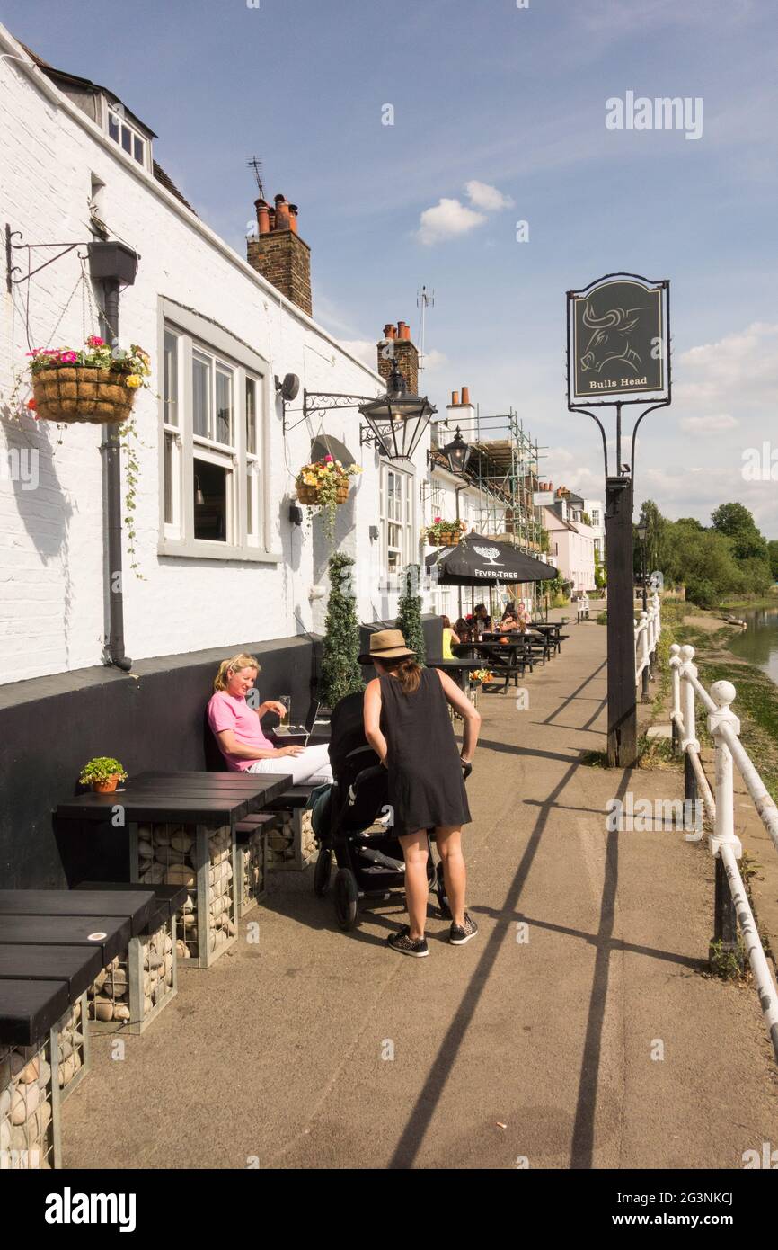 Deux femmes passant l'heure de la journée devant la Maison publique de Bull sur Strand-on-the-Green, Chiswick, Hounslow, Londres, Angleterre, ROYAUME-UNI Banque D'Images
