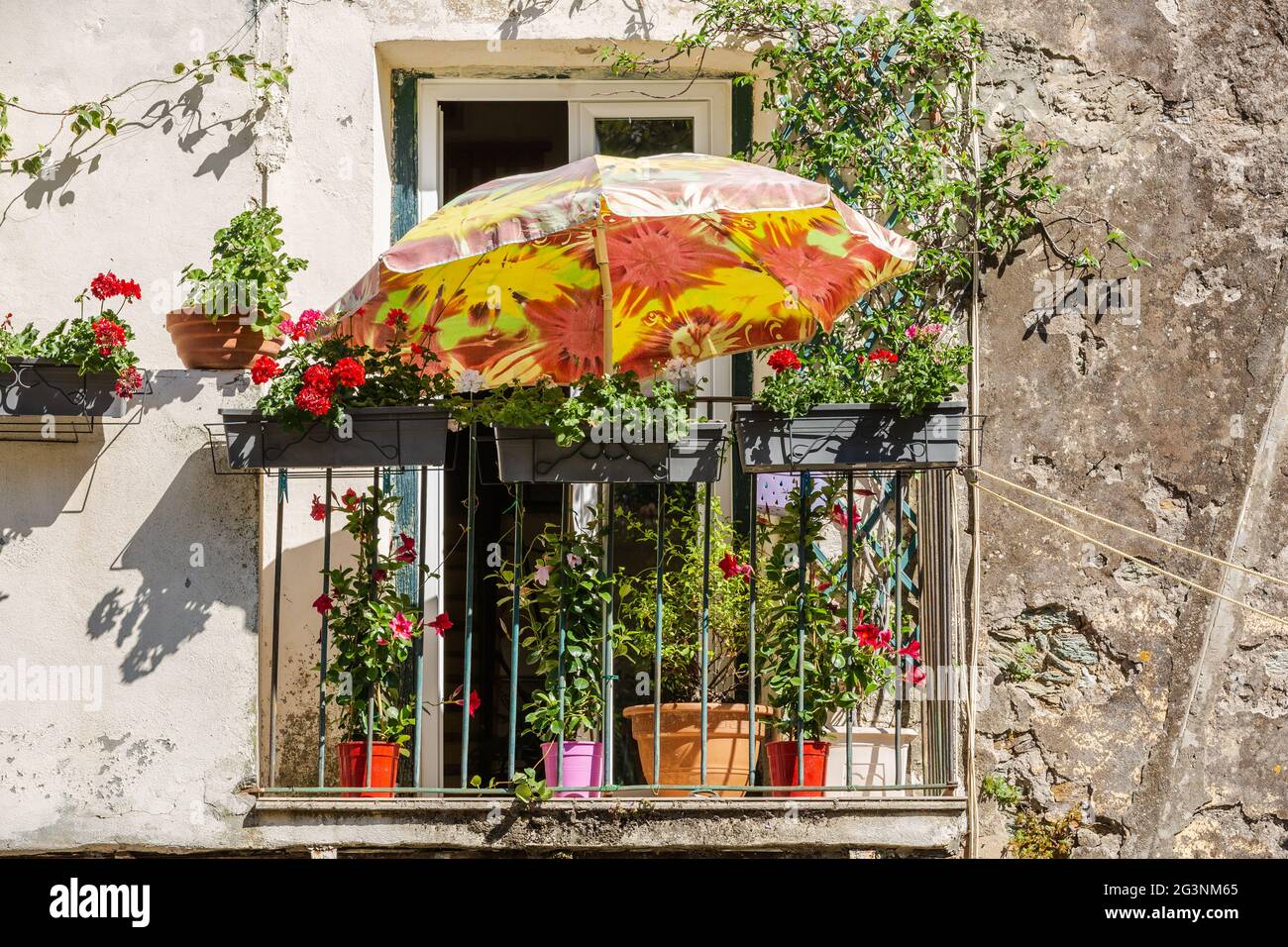 Parasol orange offrant un peu d'ombre sur un balcon d'une maison dans le  village de Cervione. Corse, France Photo Stock - Alamy