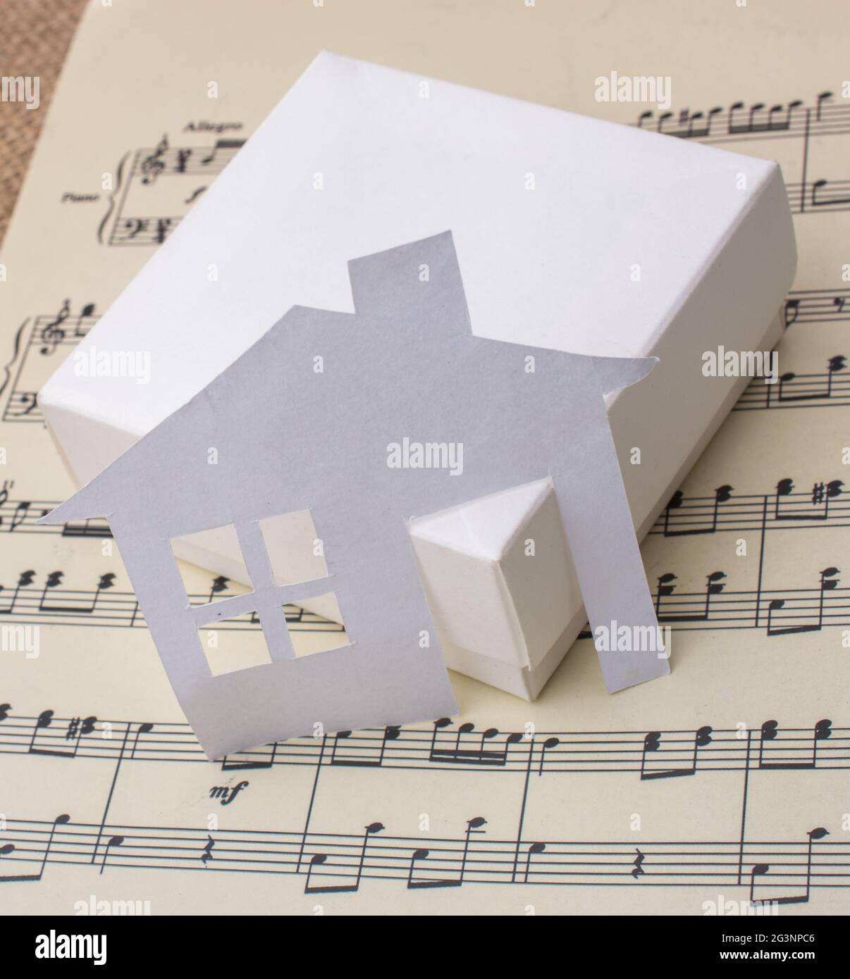 Maison de papier sur une boîte un papier avec des notes musicales Banque D'Images