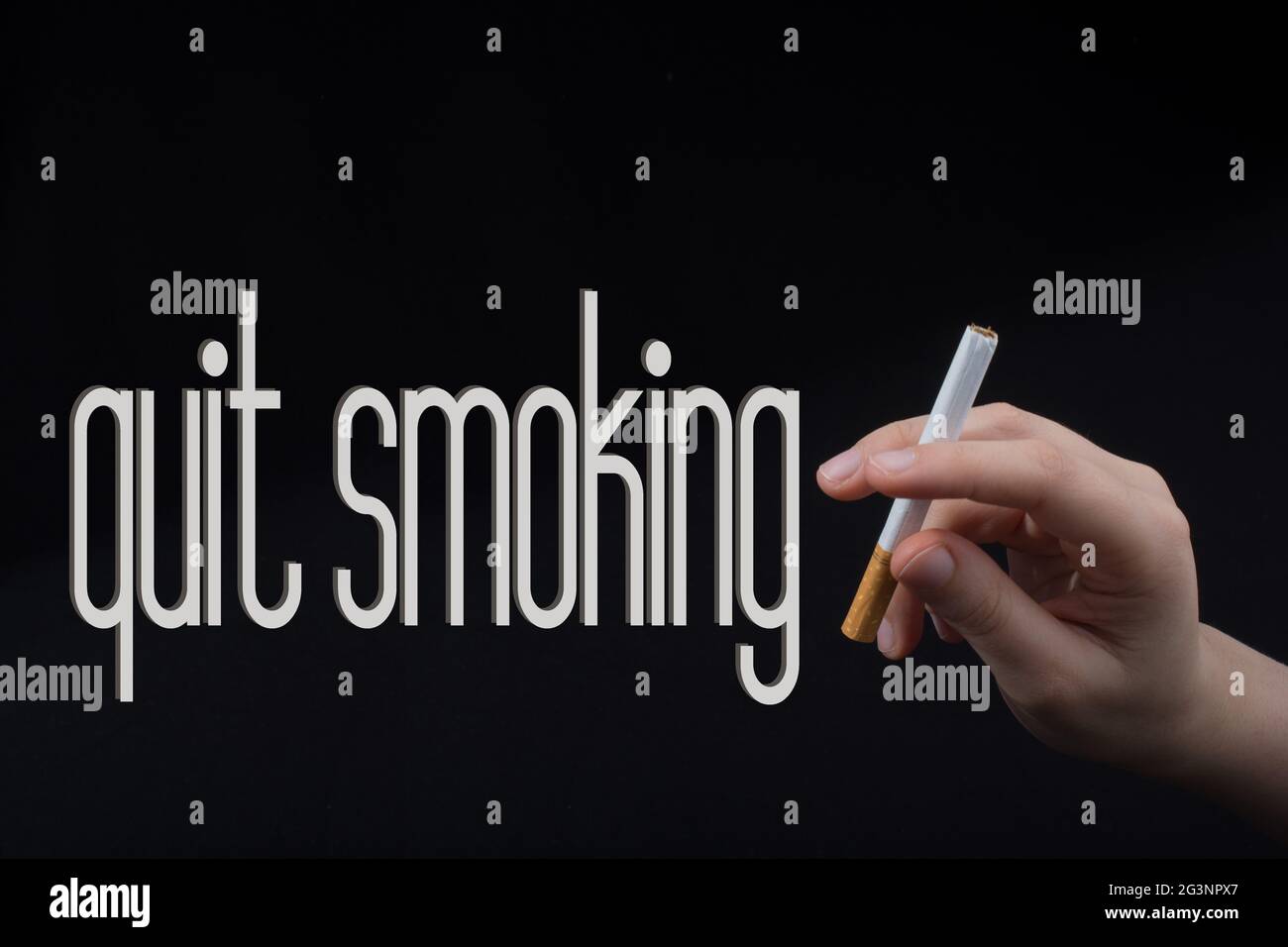C'est main tenant une cigarette sur fond noir Banque D'Images