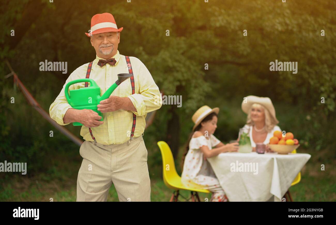 Le beau vieil homme et sa famille dans le jardin Banque D'Images