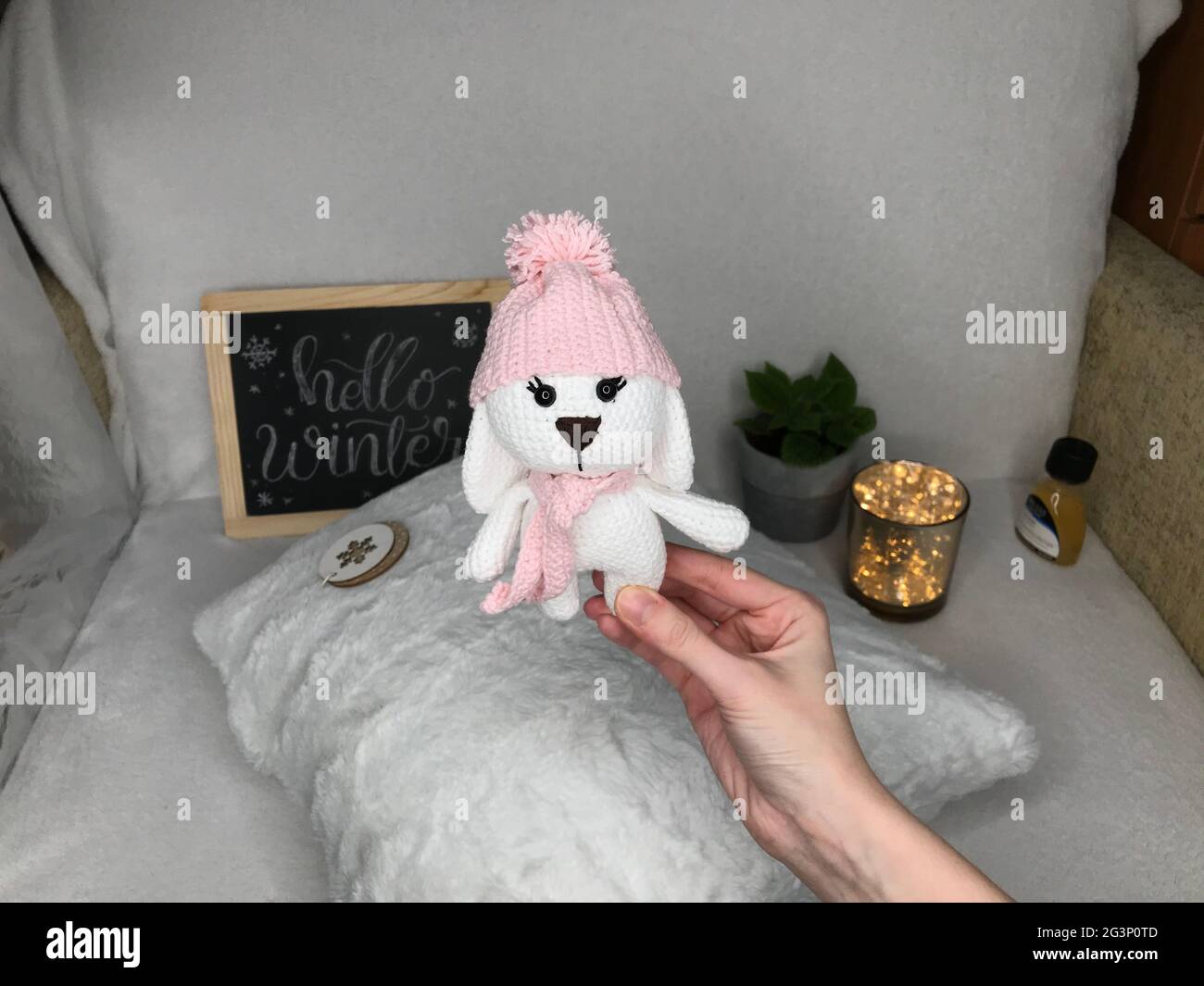 Jouet animal en crochet fait à la main - jouet en peluche Amigurumi - joli lapin avec un chapeau et une écharpe Banque D'Images