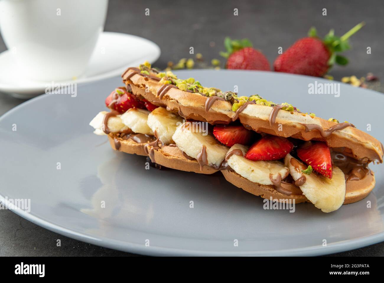 gaufres à croque-monsieur avec banane, fraise et chocolat et pistache sur le dessus Banque D'Images