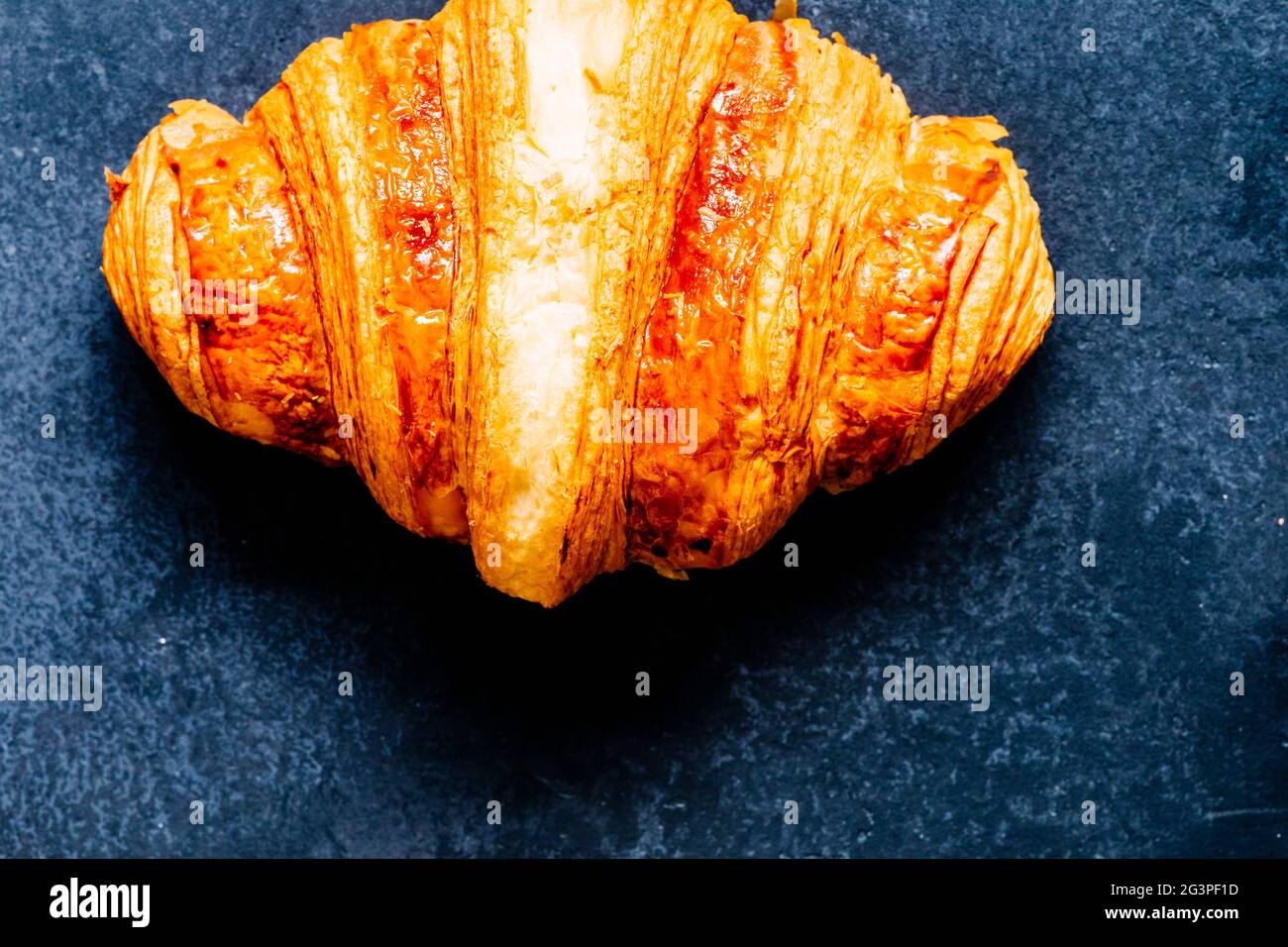 Croissant français doré sur fond sombre, vue sur le dessus de la cuisine Banque D'Images