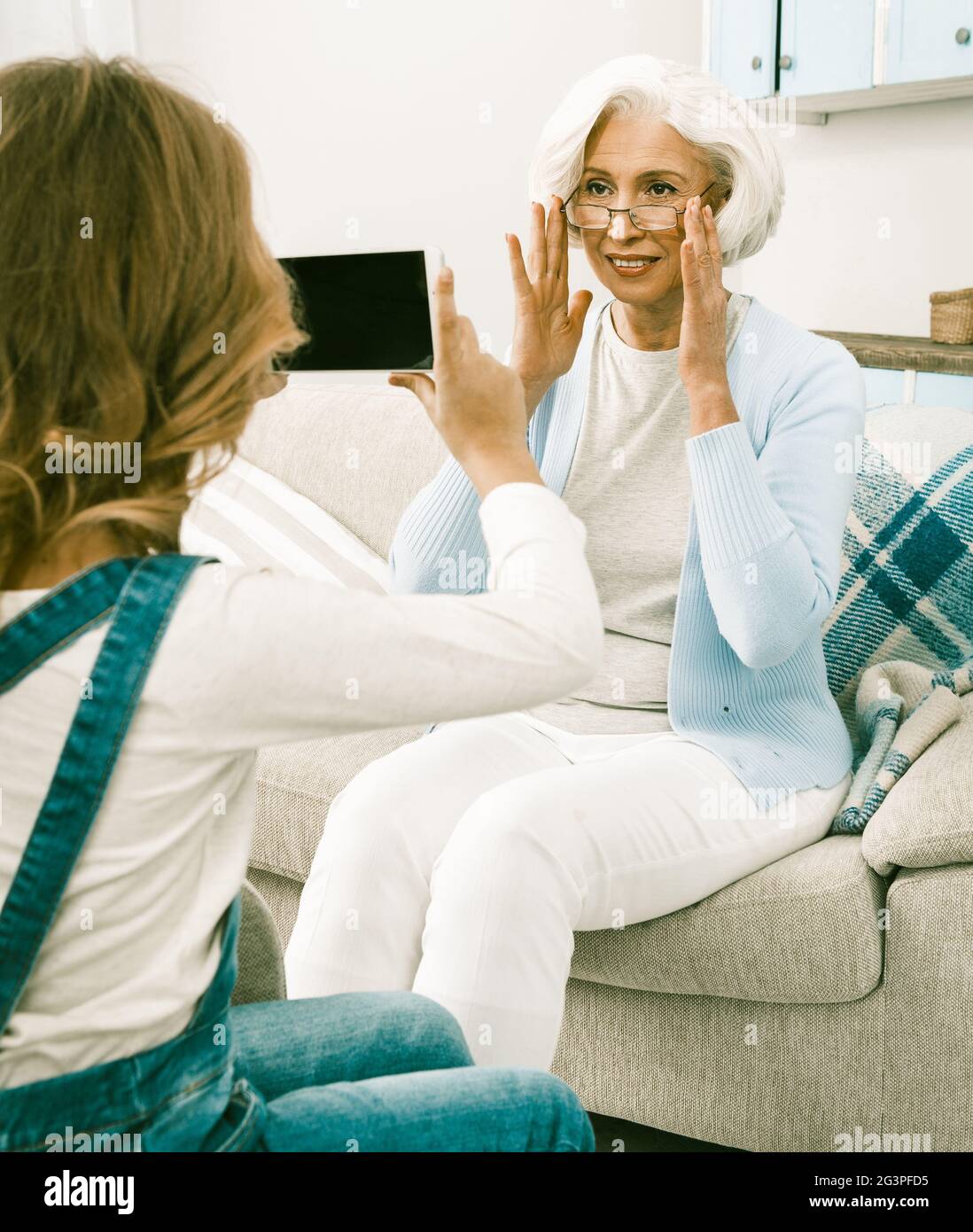 Senior White Italian Woman Posant Pour Sa Petite-Fille Learning Technologies Banque D'Images