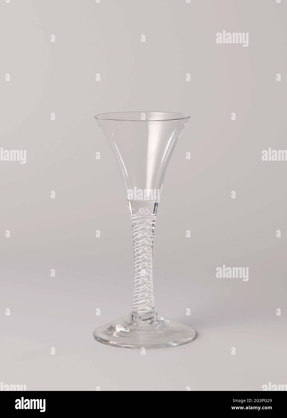 Verre lisse avec calice en forme de trompette. Verre lisse avec pied conique et tribu droite, légère et concave. Dans le tronc une guirlande blanche opaque multiple autour d'une double spirale blanche, devenant dans un calice en trompette. Banque D'Images