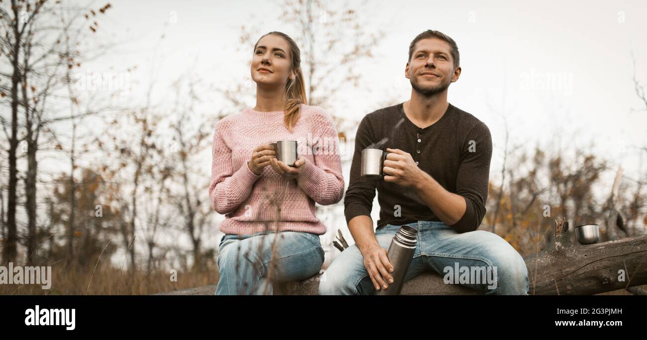 Un jeune couple se repose sur un café chaud dans la nature Banque D'Images