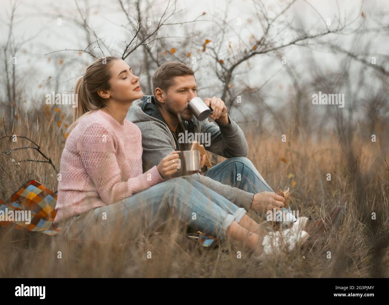 Un couple heureux boit un café en plein air au coucher du soleil Banque D'Images