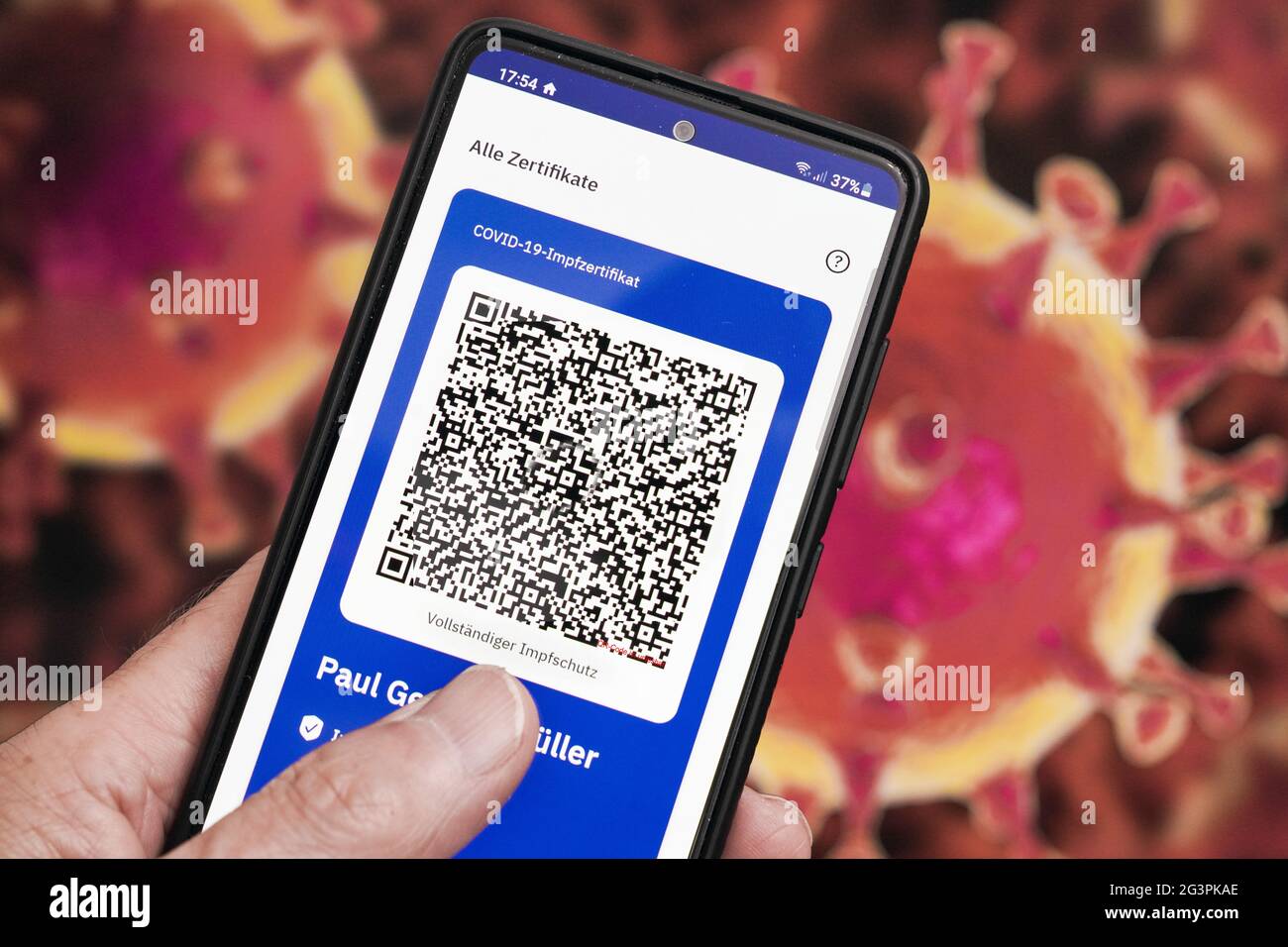 QR-Code, das digitale Impfzertifikat in der CovPass-App des Robert Koch-Instituts auf einem smartphone bestätigt eine abgeschlossenen Impfung gegen Covid-19. Liegt auf der gelben Internationalen Impfbescheinigung, Impfpass. - ACHTUNG! QR-Code und persönliche Angaben sind unkenntlich gemacht! Banque D'Images