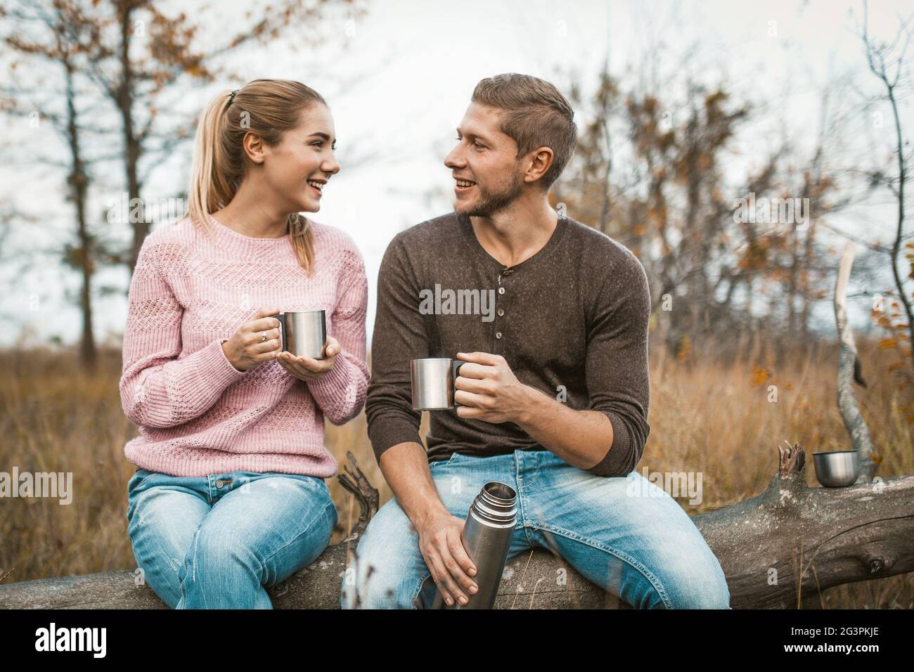 Un couple heureux qui boit une boisson chaude à l'extérieur Banque D'Images