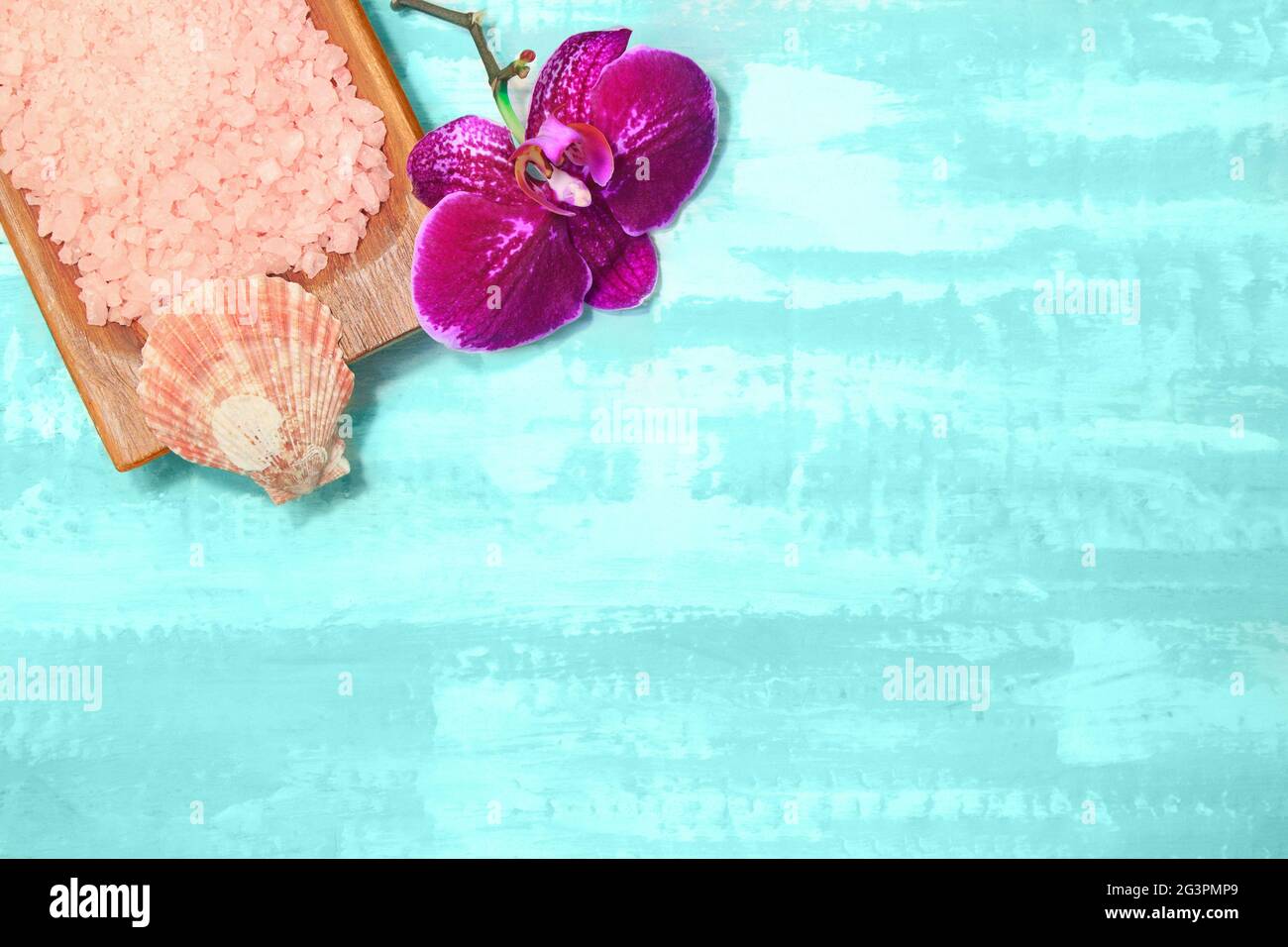 Bol en bois avec sel de mer rose et orchidée pourpre. Beauté et spa. Fond turquoise. Copier l'espace Banque D'Images