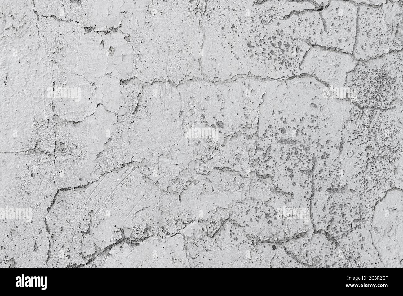 Mur en béton blanc et grundy avec fissures dans la couche de plâtrage, texture de la photo d'arrière-plan, toile de fond de construction industrielle Banque D'Images