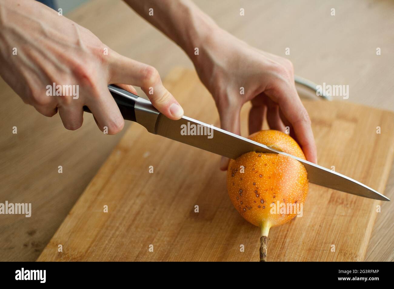 granadilla fraîche et biologique mûre ou fruit de la passion jaune coupé en deux sur une planche de bois. Fruits exotiques, concept de saine alimentation Banque D'Images