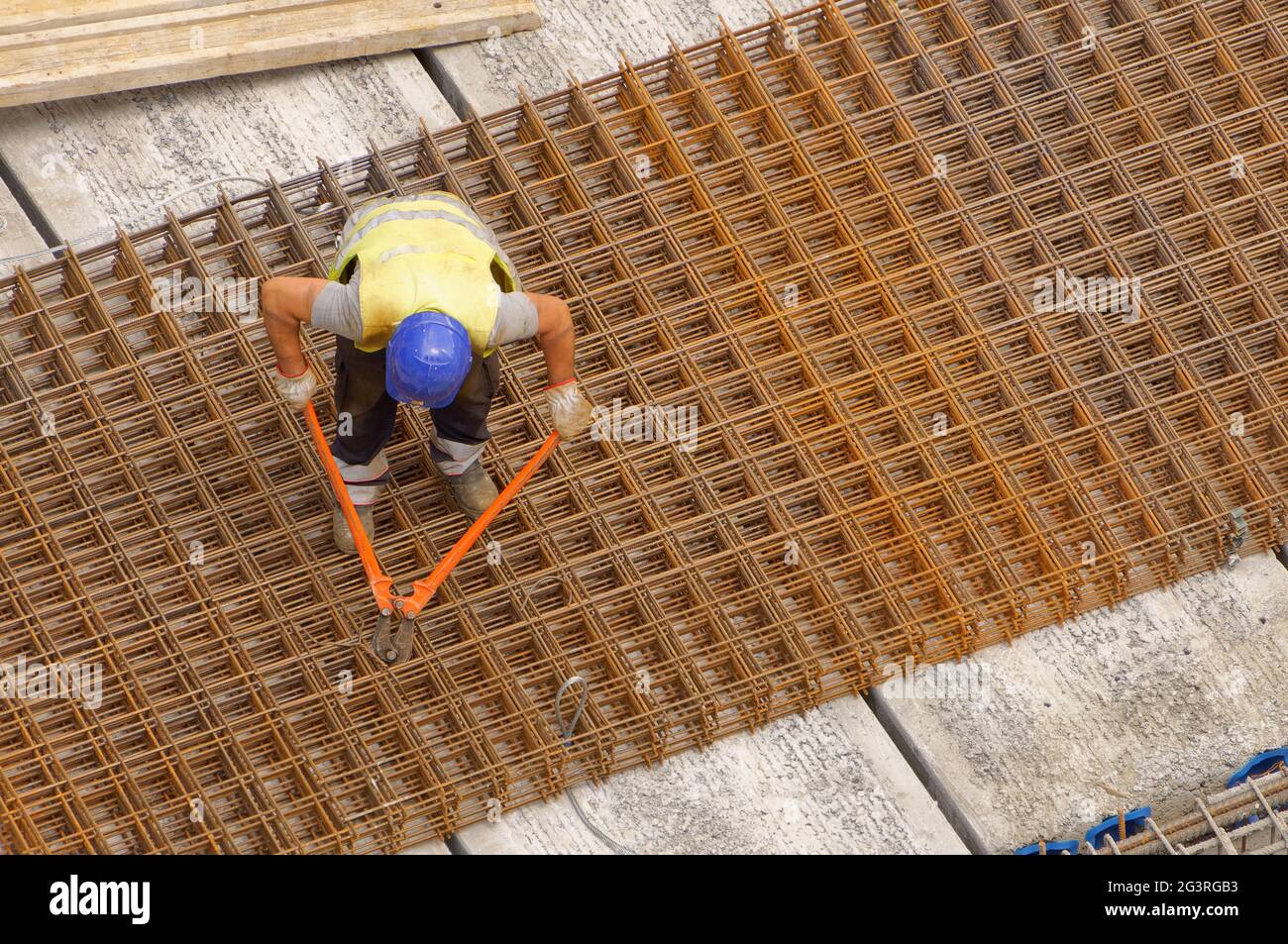 Travailleur utilisant une pince coupante sur un chantier de construction (construction) pour couper l'acier de renfort Banque D'Images