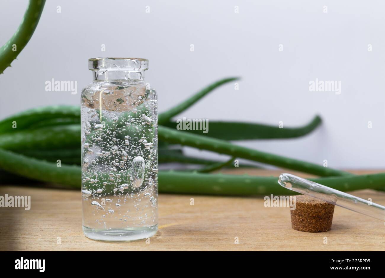 Bouteille en verre de gel d'aloe vera avec feuilles de plantes sur fond en  bois Photo Stock - Alamy