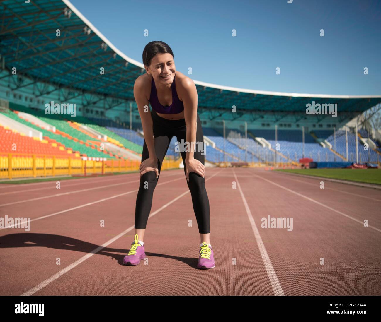 Une athlète féminine joyeuse prend une pause pendant l'entraînement Banque D'Images