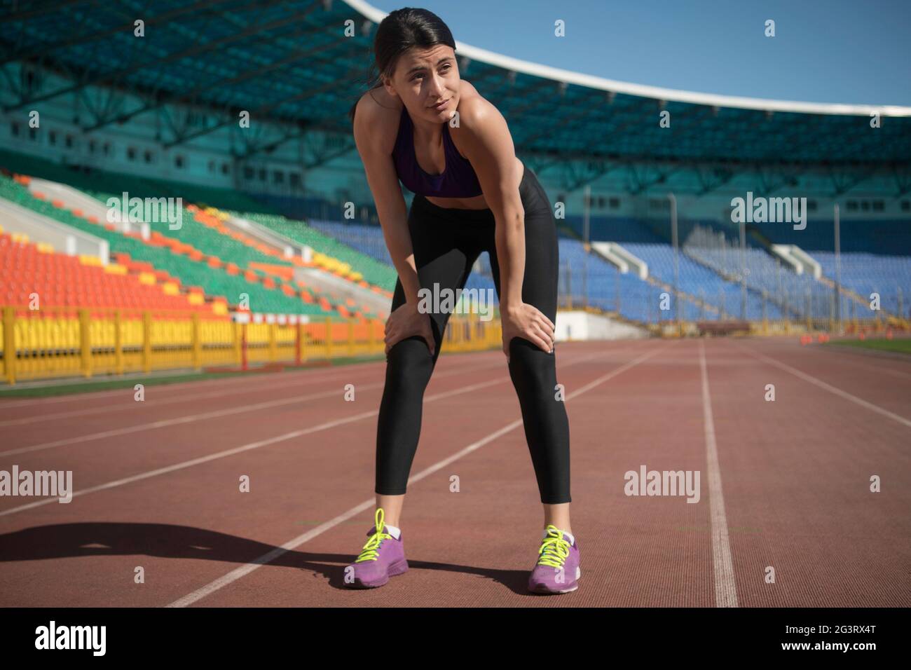 Sportswoman se reposant pendant l'entraînement sur le stade Banque D'Images