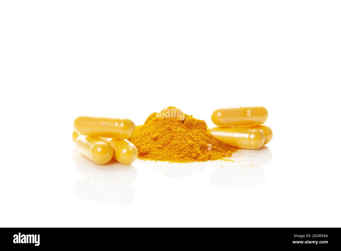 Tas de poudre de curcumine et capsules isolées sur blanc. Banque D'Images