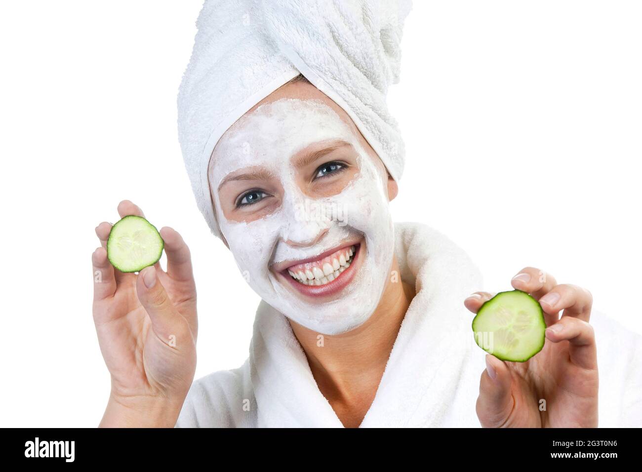 jeune femme avec masque, serviette blanche sur la tête et tranches de concombre dans les mains Banque D'Images