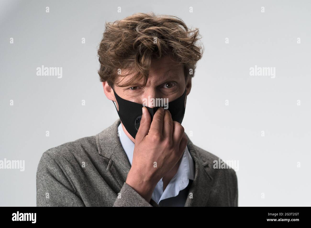 Rouge cheveux longs jeune homme en masque. Banque D'Images