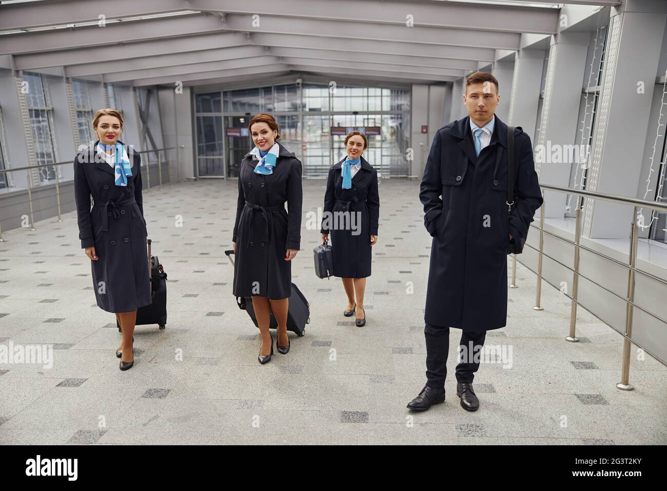 Équipe d'avions avec bagages près de l'entrée de l'aéroport Banque D'Images