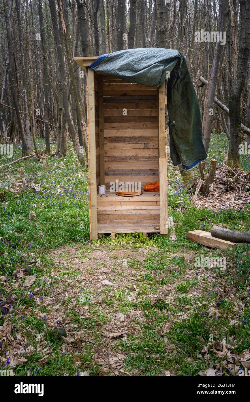 toilettes extérieures en bois entourées d'arbres dans une forêt Banque D'Images