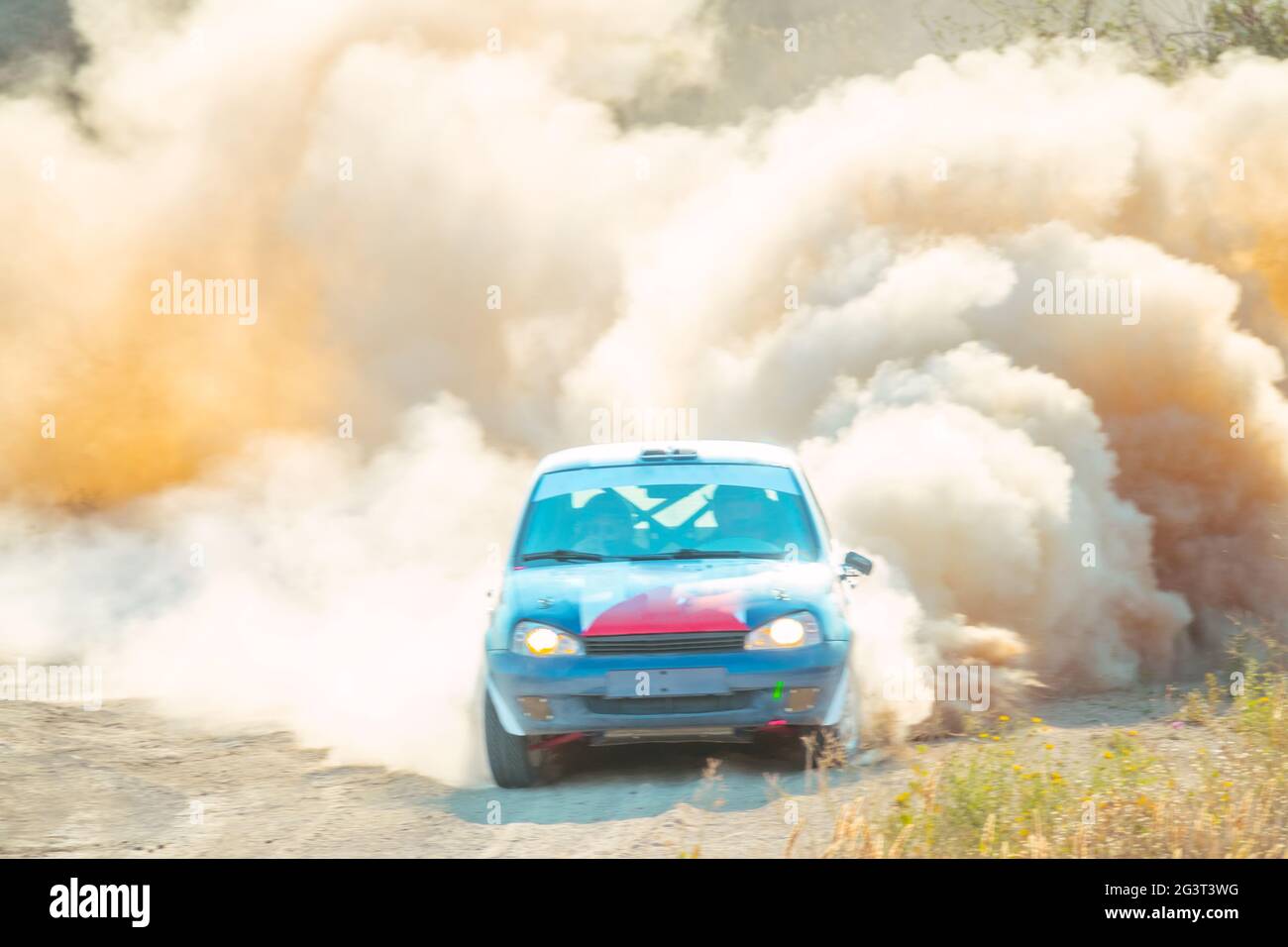 La voiture de rallye roule avec un gros nuage de poussière Banque D'Images