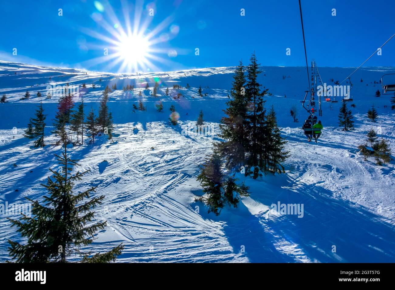 Soleil éclatant sur une piste de ski non équipée et un télésiège Banque D'Images