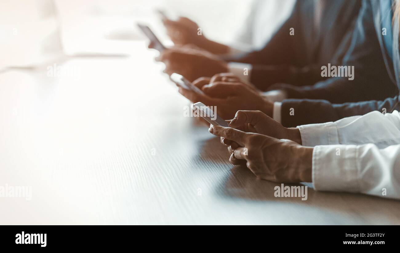 Les travailleurs indépendants se sont mis en ligne à l'aide de l'application de test des smartphones ou des mises à jour à la table. Image floue. Accent sélectif sur la fema Banque D'Images