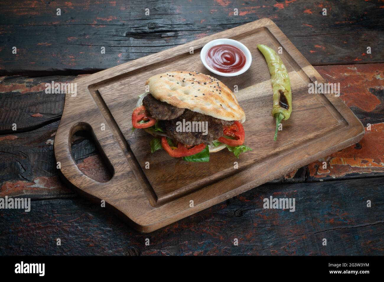 Sandwich au meatball avec tomates, oignons et poivre vert sur fond rustique en bois Banque D'Images