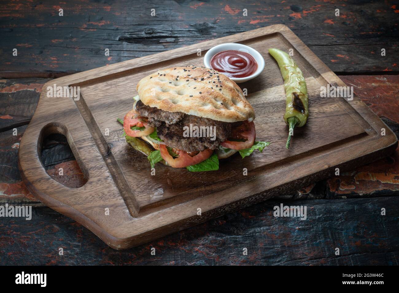 Sandwich au meatball avec tomates, oignons et poivre vert sur fond rustique en bois Banque D'Images
